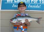 A young boy holding a fish at SUGAR BARGE RV RESORT AND MARINA - thumbnail