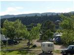 RVs in a campsite with sites shaded by trees at TURQUOISE TRAIL CAMPGROUND & RV PARK - thumbnail