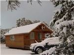 A cabin and SUV covered in a layer of snow at TURQUOISE TRAIL CAMPGROUND & RV PARK - thumbnail