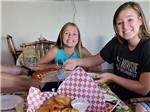 Two girls eating pizza at OSPREY POINT RV RESORT - thumbnail