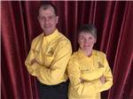 A man and woman with yellow KOA shirts standing in front of a red drape at GROS MORNE/NORRIS POINT KOA - thumbnail