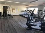 A fitness gym with wood floor, treadmills and exercise bikes at SUNRISE RV RESORT - thumbnail