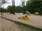 Playground equipment in the sand at STONE CREEK RV PARK - thumbnail