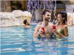A couple enjoying a drink in the pool at PARAGON CASINO RV RESORT - thumbnail