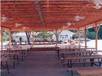 Covered outdoor patio area with many community tables at KING'S HOLLY HAVEN RV PARK - thumbnail