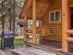 An outdoor bench swing on the porch of a cabin at THE NUGGET RV RESORT - thumbnail