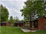A row of rustic rental log cabins at VACATION STATION RV RESORT - thumbnail