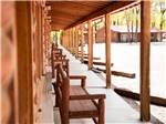 A row of wooden benches under an awning at THE LONGHORN RANCH LODGE AND RV RESORT - thumbnail