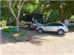 Big rig in a shady site with dinghy at COLORADO LANDING RV PARK - thumbnail