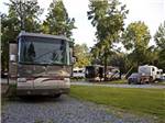 A motorhome in a gravel RV site at LAKE PINES RV PARK & CAMPGROUND - thumbnail