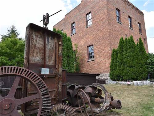 A piece of rusty machinery in front of a brick building at NICOLSTON DAM CAMPGROUND & TRAVELLERS PARK