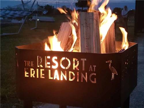 A lit fire pit with the resort logo at THE RESORT AT ERIE LANDING
