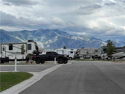 A paved road thru the RV sites with mountains in the background at ASPEN GROVE RV PARK