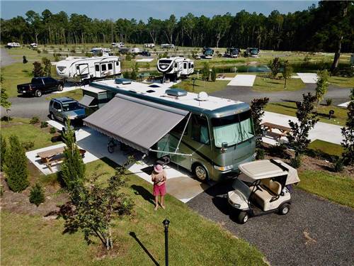 Camper and golf cart in campsite at MADISON RV & GOLF RESORT
