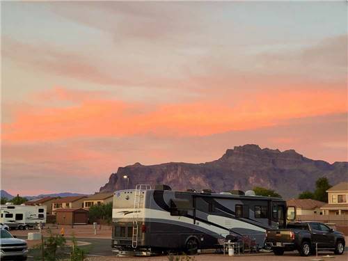 A motorhome parked in a site at sunset at CAMPGROUND USA RV RESORT