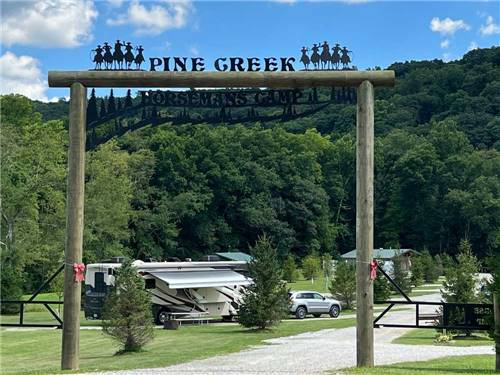 Sign mounted over campground entrance announcing Pine Creek at PINE CREEK CABINS AND CAMPGROUND