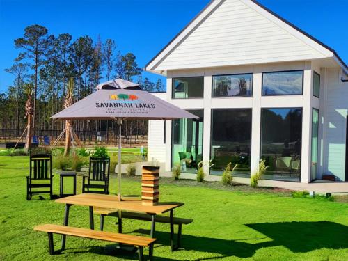 A picnic bench with an umbrella and a game on it at SAVANNAH LAKES RV RESORT