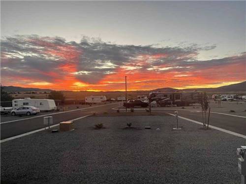 RVs parked in gravel sites at sunset at WHISTLESTOP LUXURY RV PARK