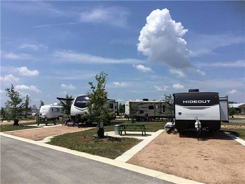 A row of trailers parked in gravel sites at SCHATZILAND RV RESORT