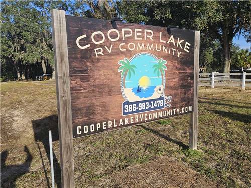 The front entrance sign and a flag at COOPER LAKE RV COMMUNITY