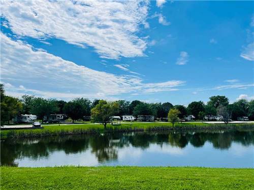 Blue sky over the water, campsite in the background at NEW VISION RV PARK
