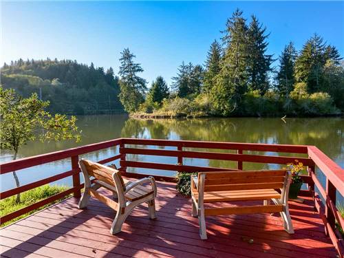 A deck with benches overlooking the water at HOQUIAM RIVER RV PARK