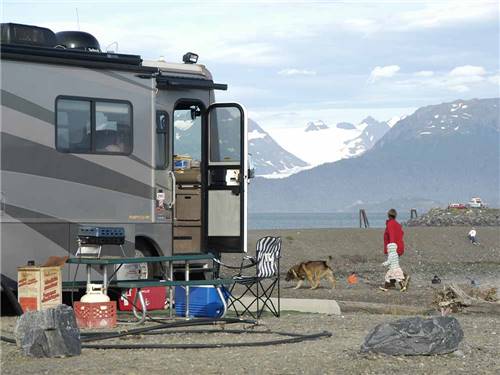 A family and dog walking in front of a motorhome at HERITAGE RV PARK