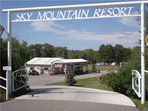 The front driveway with a sign over the road at SKY MOUNTAIN RESORT RV PARK