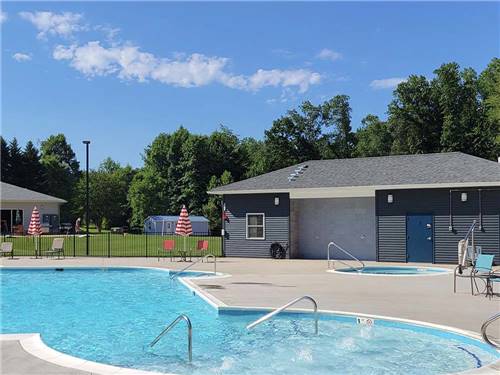 Swimming pool and hot tub under sunny sky at MADISON VINES RV RESORT & COTTAGES
