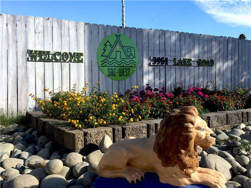 Sign leading into campground resort with lion statue in front at SAC-WEST RV PARK AND CAMPGROUND