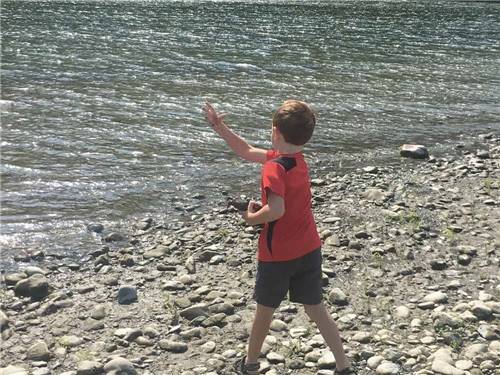 A boy throwing a rock into the ocean at KLAMATH CAMPER CORRAL