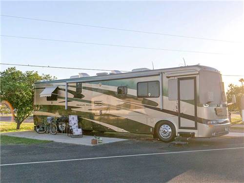 Large RV camping with bike on the side at ENCORE ALAMO PALMS