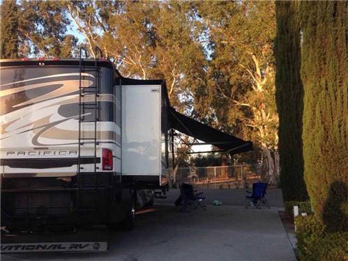 Large brown, tan and white travel trailer with awning at SANTA NELLA RV PARK