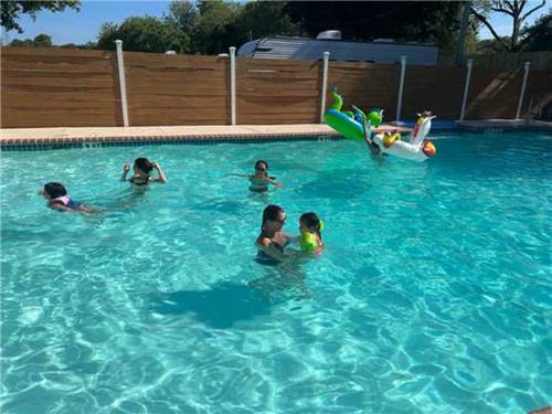 Campers enjoying the swimming pool at HATCH RV PARK