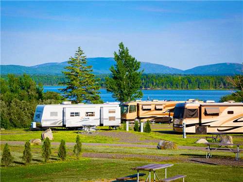 Large trailers and RVs parked alongside large lake at NARROWS TOO CAMPING RESORT