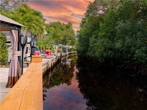 RVs parked at pier facing water and trees at NORTHTIDE NAPLES RV RESORT
