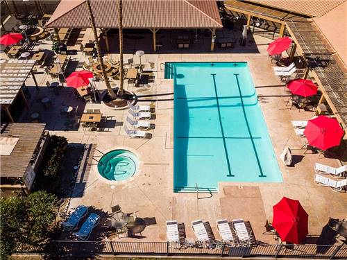 Aerial view over pool and spa with red umbrellas at RIO BEND RV & GOLF RESORT