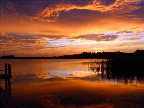 An orange sunset over the water at LELYNN RV RESORT