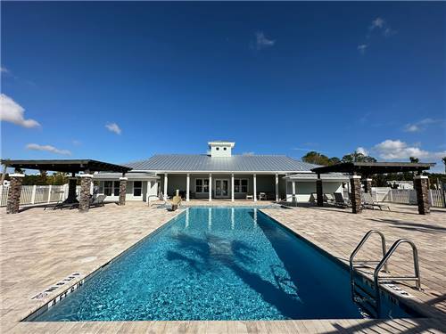 Rectangular pool with elegant building nearby at ST AUGUSTINE RV RESORT