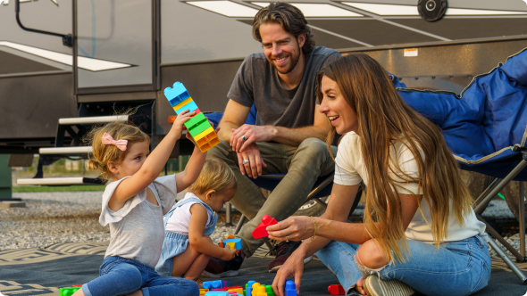 Parents overjoyed watching their kids playing with blocks on the sand 