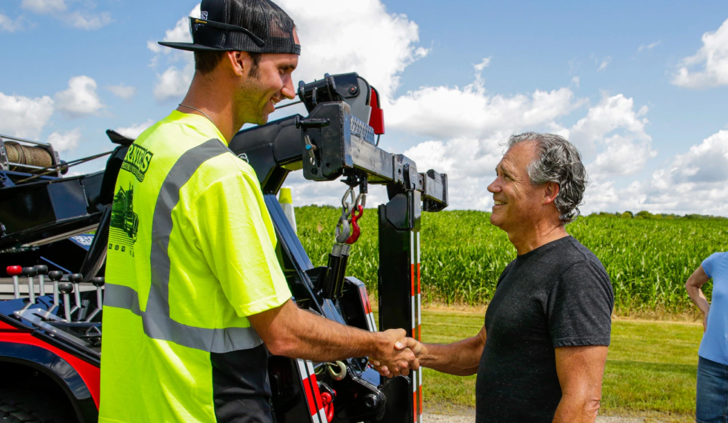 towing service member shaking hands with customer