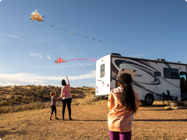 campers flying kites near their RV