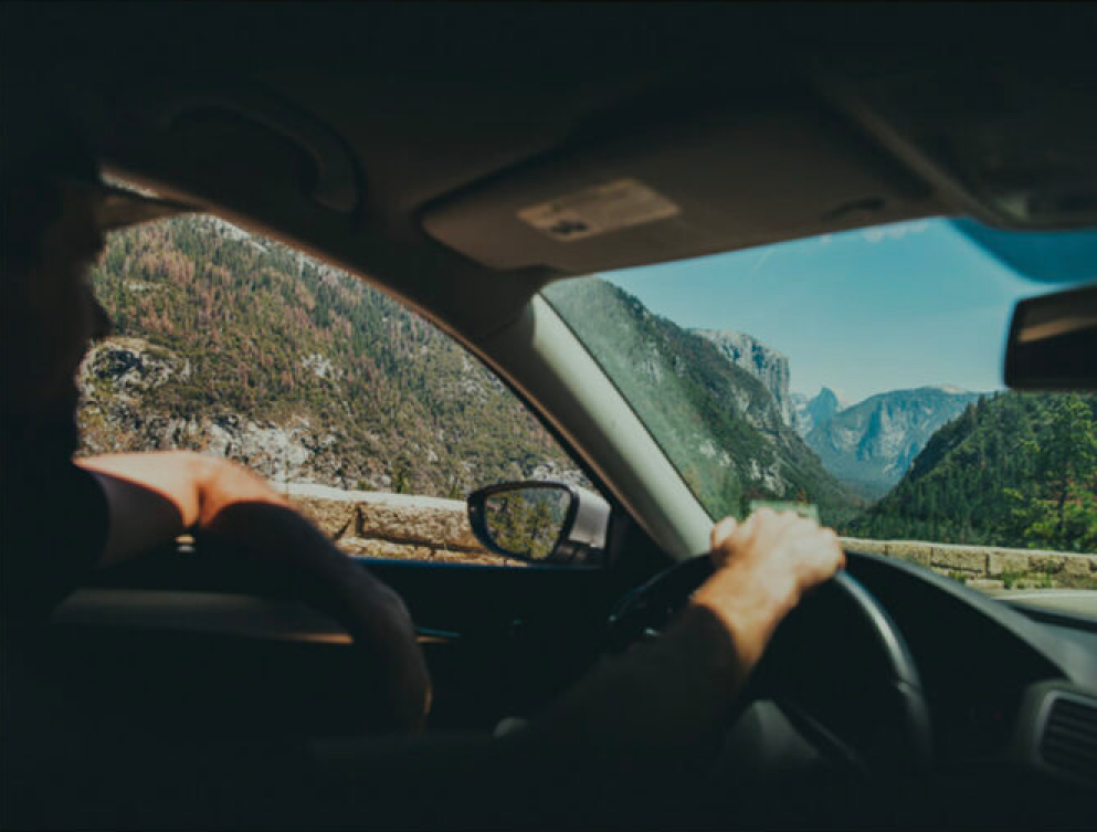 person driving by the mountains