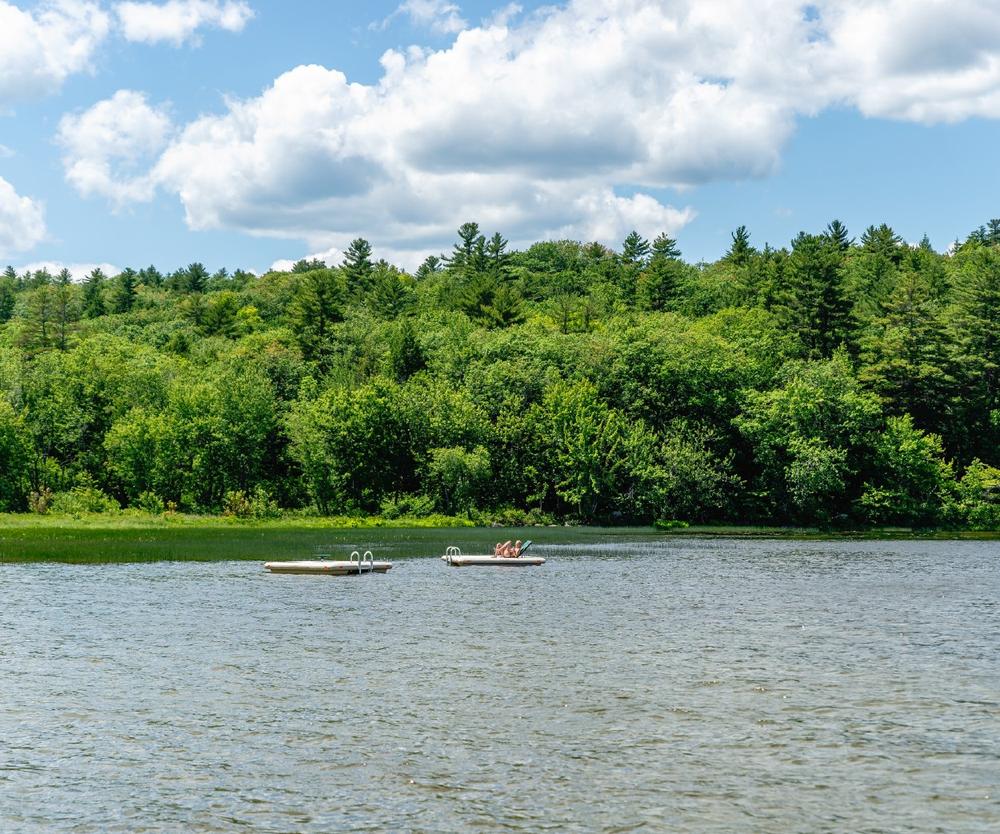 A woman sunning on the lake at Jellystone Park Androscoggin Lake