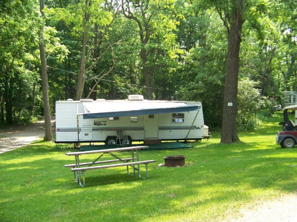 Trailer in grassy RV site at Spruce Row Campground & RV Park