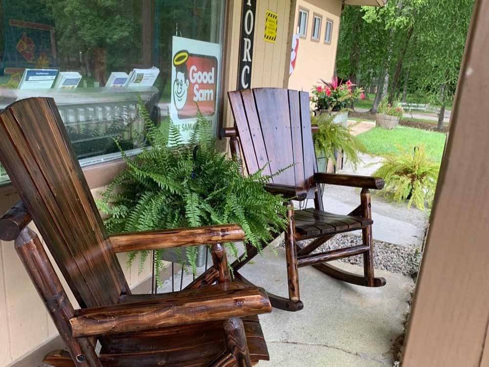 Wooden rocking chairs outside the main building at SOUTH FORTY RV CAMPGROUND