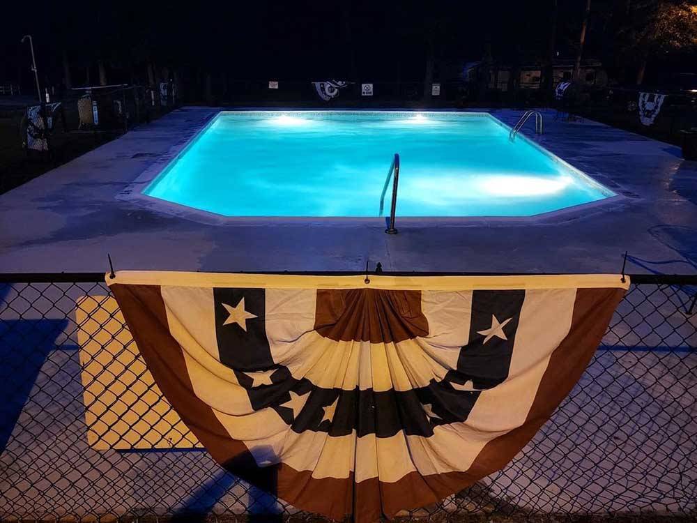 The outdoor pool lit up at night at SOUTH FORTY RV CAMPGROUND