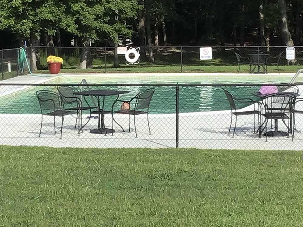 Tables and chairs outside the outdoor pool at SOUTH FORTY RV CAMPGROUND