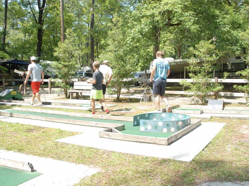 A group of people playing miniature golf at GREEN ACRES FAMILY CAMPGROUND