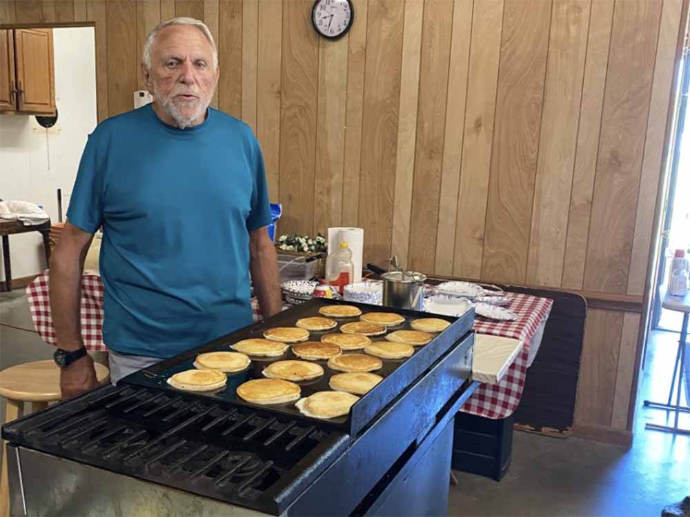 A man cooking a lot of pancakes at GREEN ACRES FAMILY CAMPGROUND